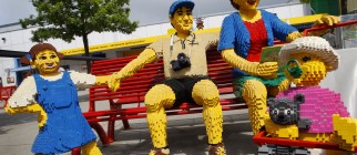 A family made of Lego bricks sit on a be