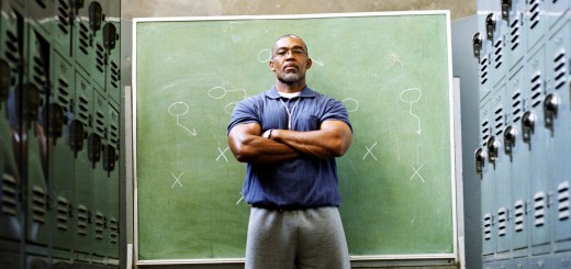 Coach in locker room, standing in front of chalkboard