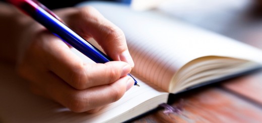 Close-up of hand pen writes in a notebook