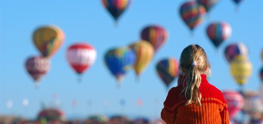 girl watching balloons in crowd